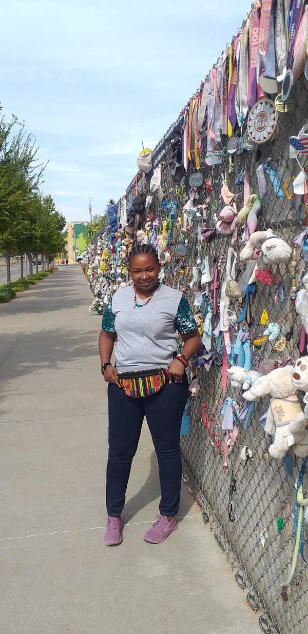 Fides standing next to the Oklahoma City National Bombing Memorial & Museum’s Memorial Wall