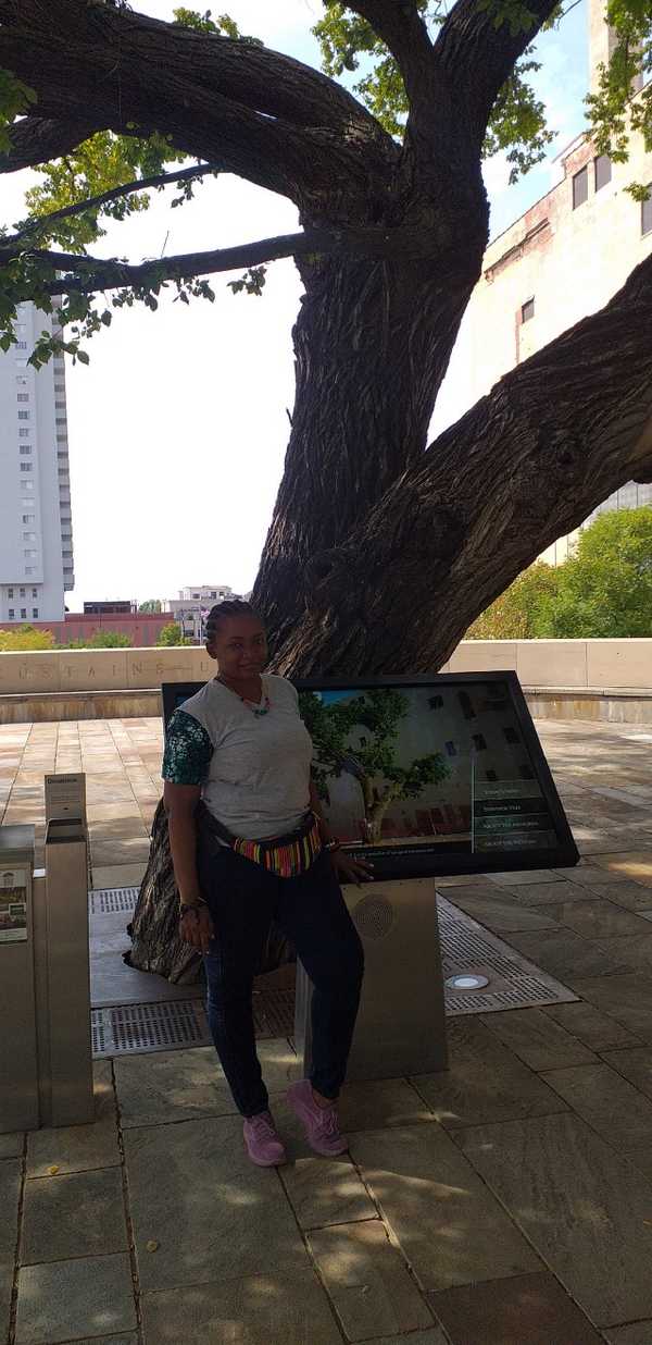 Woman standing next to Survivors Tree