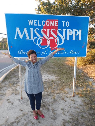 I am posing in front of the Welcome to Mississippi sign.